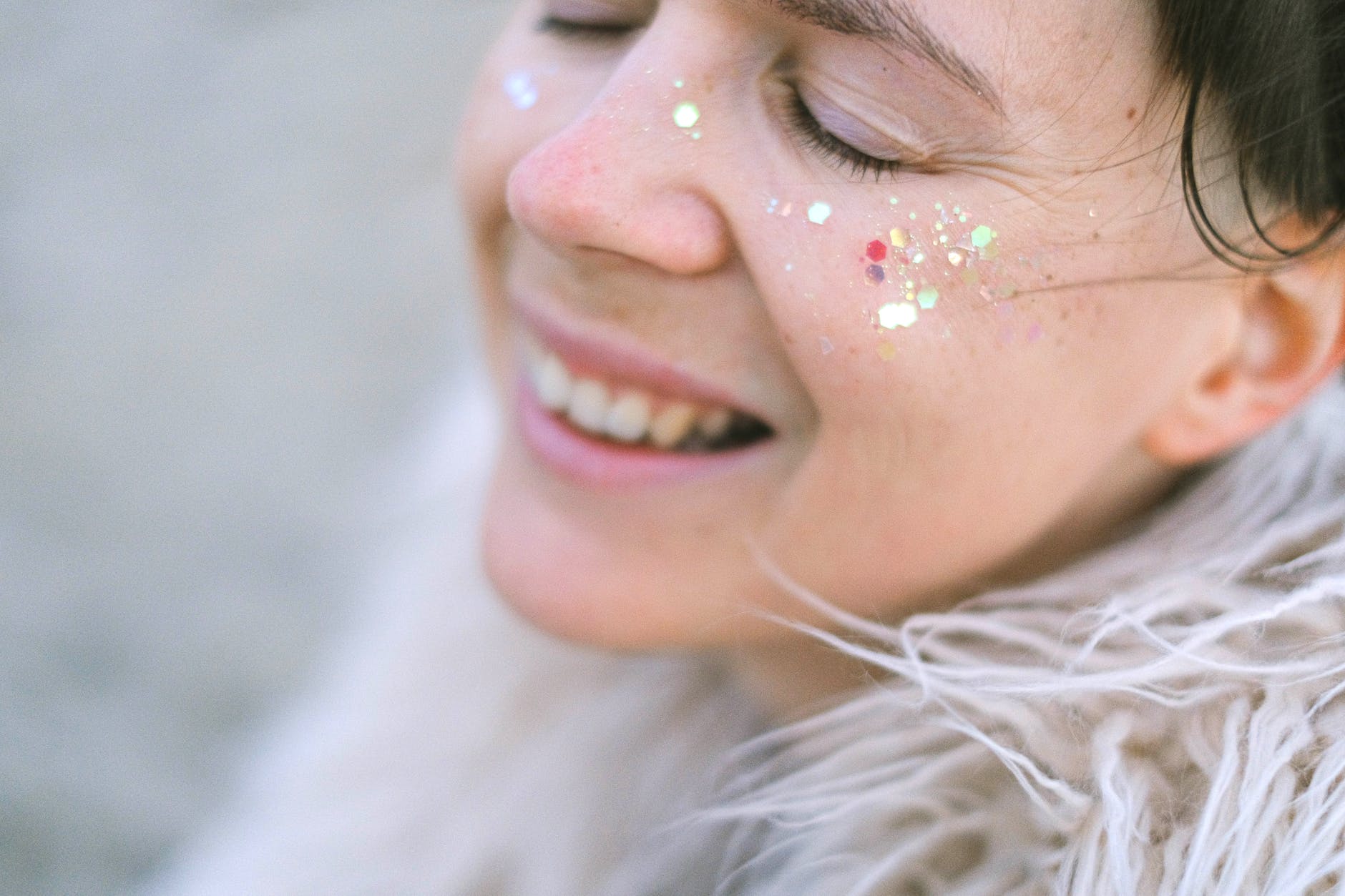 woman with spangles on cheeks laughing
